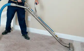 Professional operating a liquid removal machine on a carpeted floor in Overland Park, KS